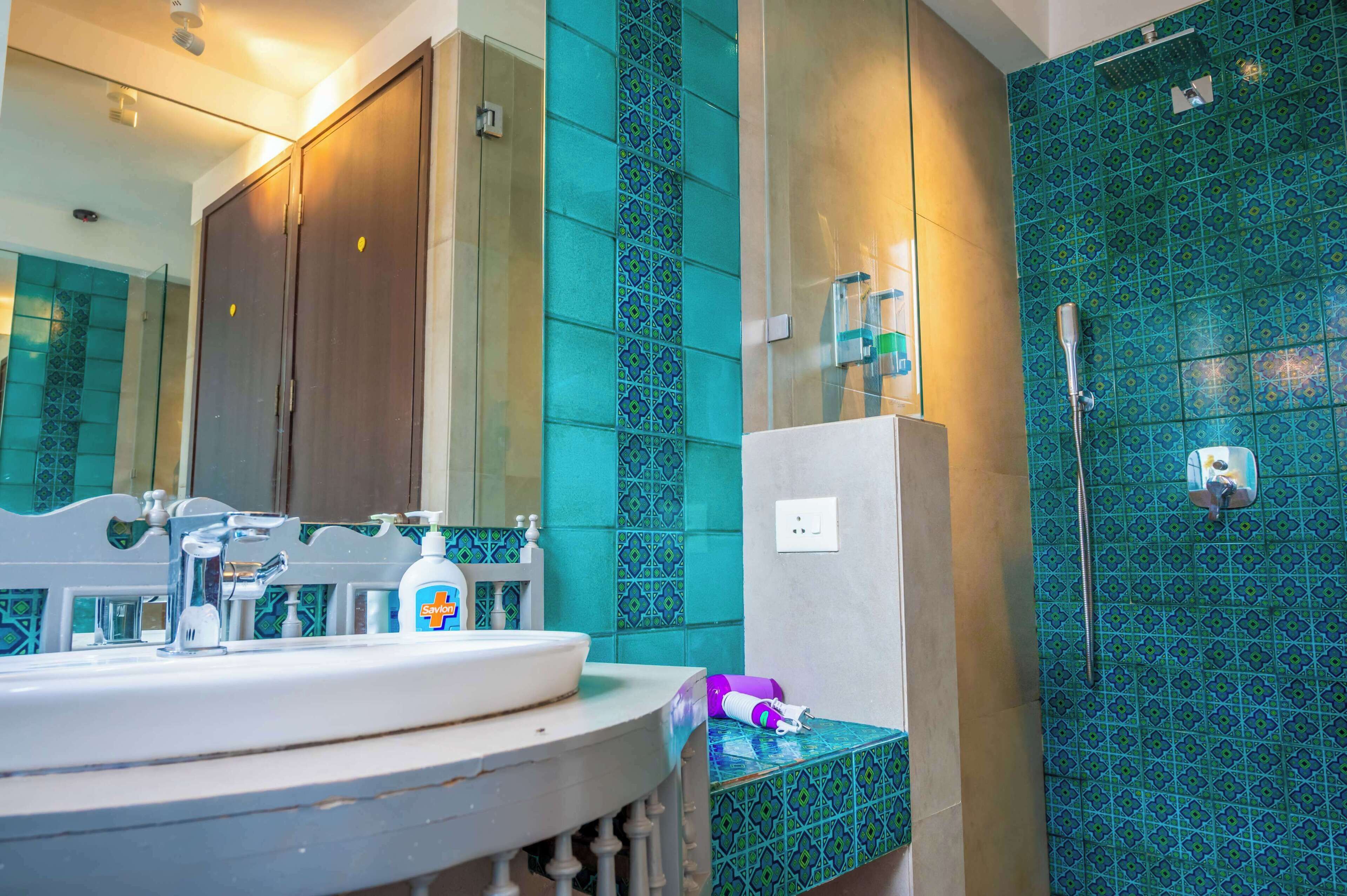 A bathroom with a sink, mirror, and shower area.