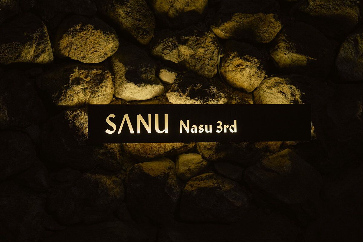 A stone wall with the text "SANU Nasu 3rd" on it.