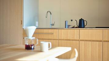 A modern kitchen with wooden cabinets, a stainless steel sink, and a coffee maker on the counter.