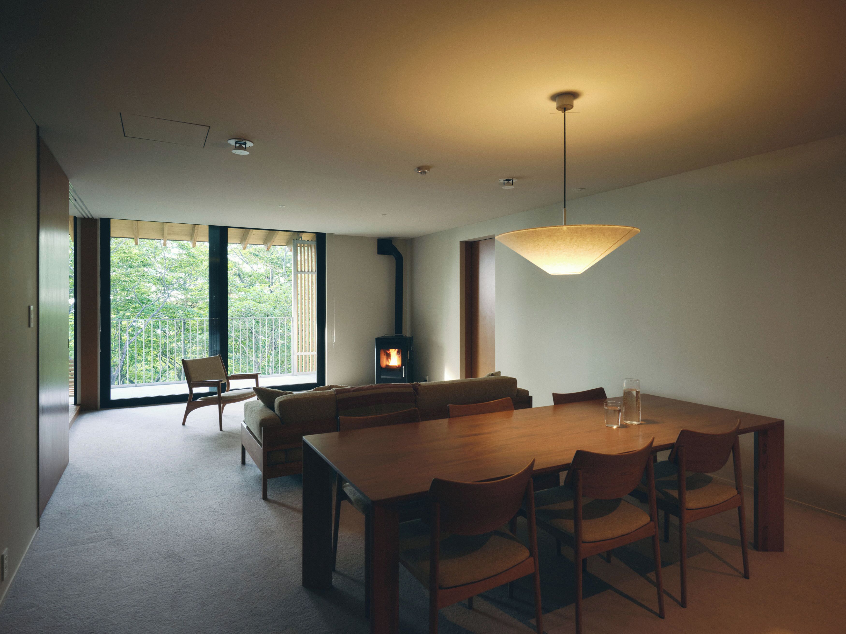 Un espace repas moderne avec une table et des chaises en bois, un canapé et une cheminée.