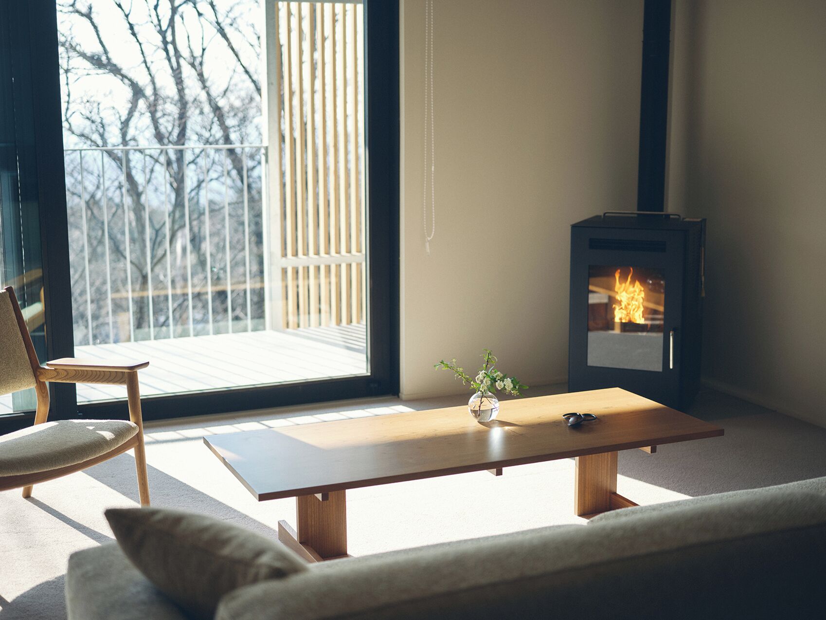 Una sala de estar acogedora con una mesa de madera, un sofá, un sillón y una chimenea.