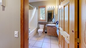 Een badkamer met een bad, toilet en wastafel.
