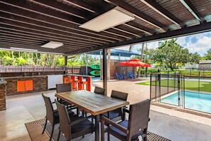 An outdoor patio with a pool, a barbecue area, and a seating arrangement. - Waterfront 3BR with Pool, Tiki Hut & Mini Golf (Miami Gardens)