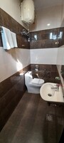 Ein Badezimmer mit Toilette, Bidet, Waschbecken und Handtuchhalter.
