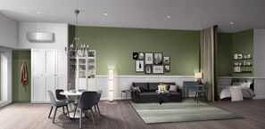 A modern living room with a green accent wall, a white fireplace, a dining area with a round table and chairs, and a sofa with a coffee table. - Legacy Modern Suits (Valencia)