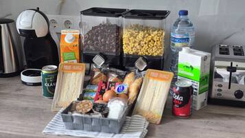 A kitchen counter with various food items and kitchen appliances.