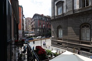 Une vue de rue avec des immeubles, un fourgon blanc et des piétons.