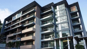 Un immeuble à plusieurs étages doté de balcons, de grandes fenêtres et d’une architecture moderne.