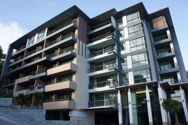 Un edificio a più piani con balconi, ampie finestre e un design architettonico moderno.