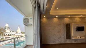 A balcony with a view of a temple, a mounted air conditioner, and a flat-screen TV.