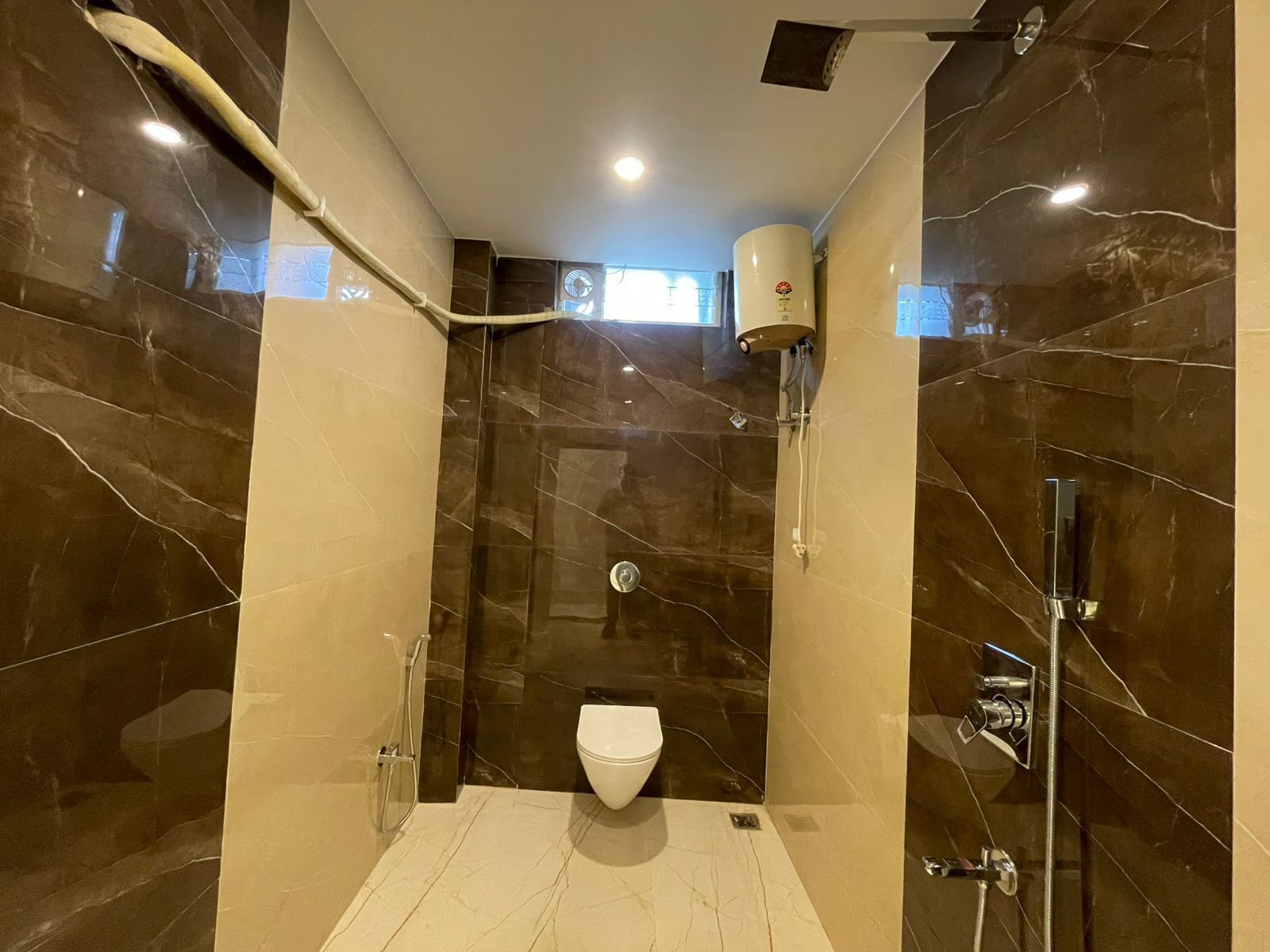 Une salle de bain moderne équipée de toilettes, d’une douche et d’un meuble-lavabo.