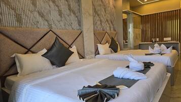 A hotel room with two beds, each with white linens and pillows, a marble-patterned wall, and a modern design.