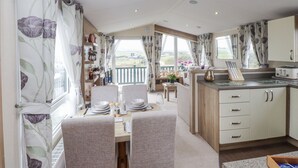 A cozy kitchen with a dining area, wooden cabinets, and a view of the countryside.