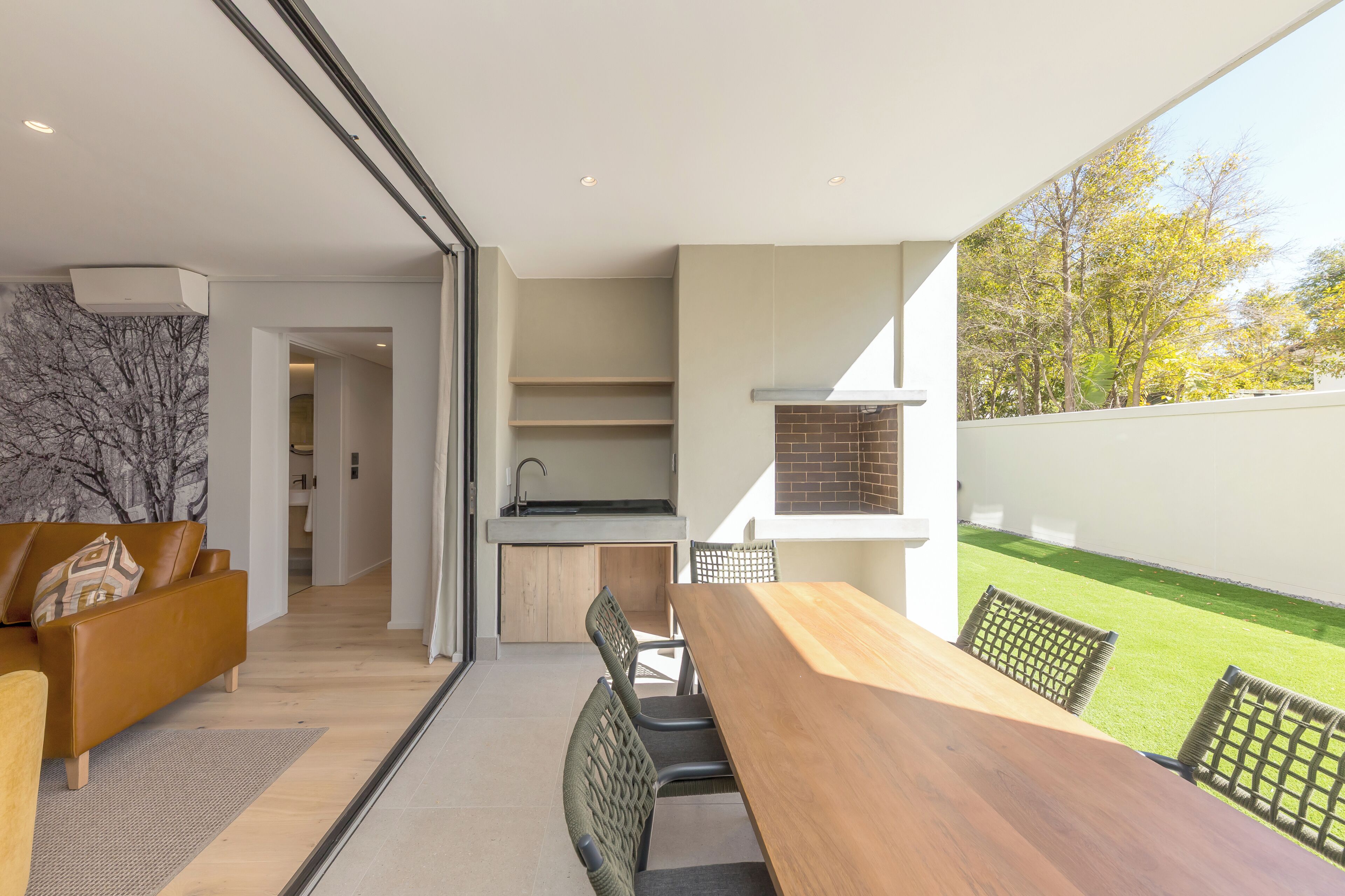 Una cocina moderna con horno empotrado y comedor con mesa y sillas de madera.