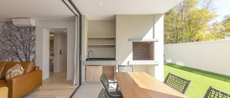 Una cocina moderna con horno empotrado y comedor con mesa y sillas de madera.