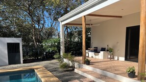 Une terrasse extérieure moderne avec une piscine, entourée de gravier et de plantes.