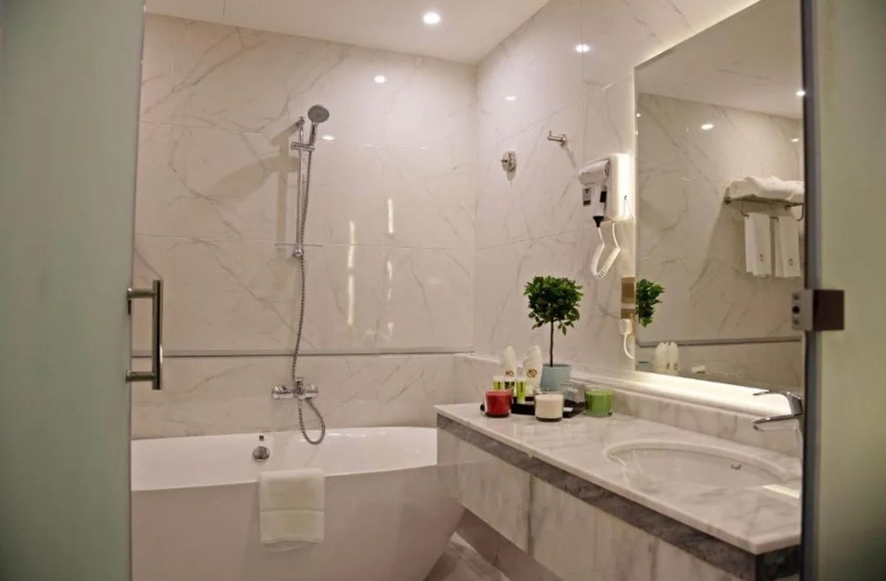 Un baño moderno con bañera, ducha, espejo grande y lavabo.
