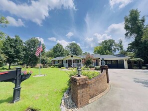 A two-story house with a front porch, a garage, and a well-maintained lawn. - Beautiful Villa with a private pool (Little River)