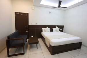 Quarto com cama, escrivaninha, cadeira, guarda-roupa e ventoinha no teto.