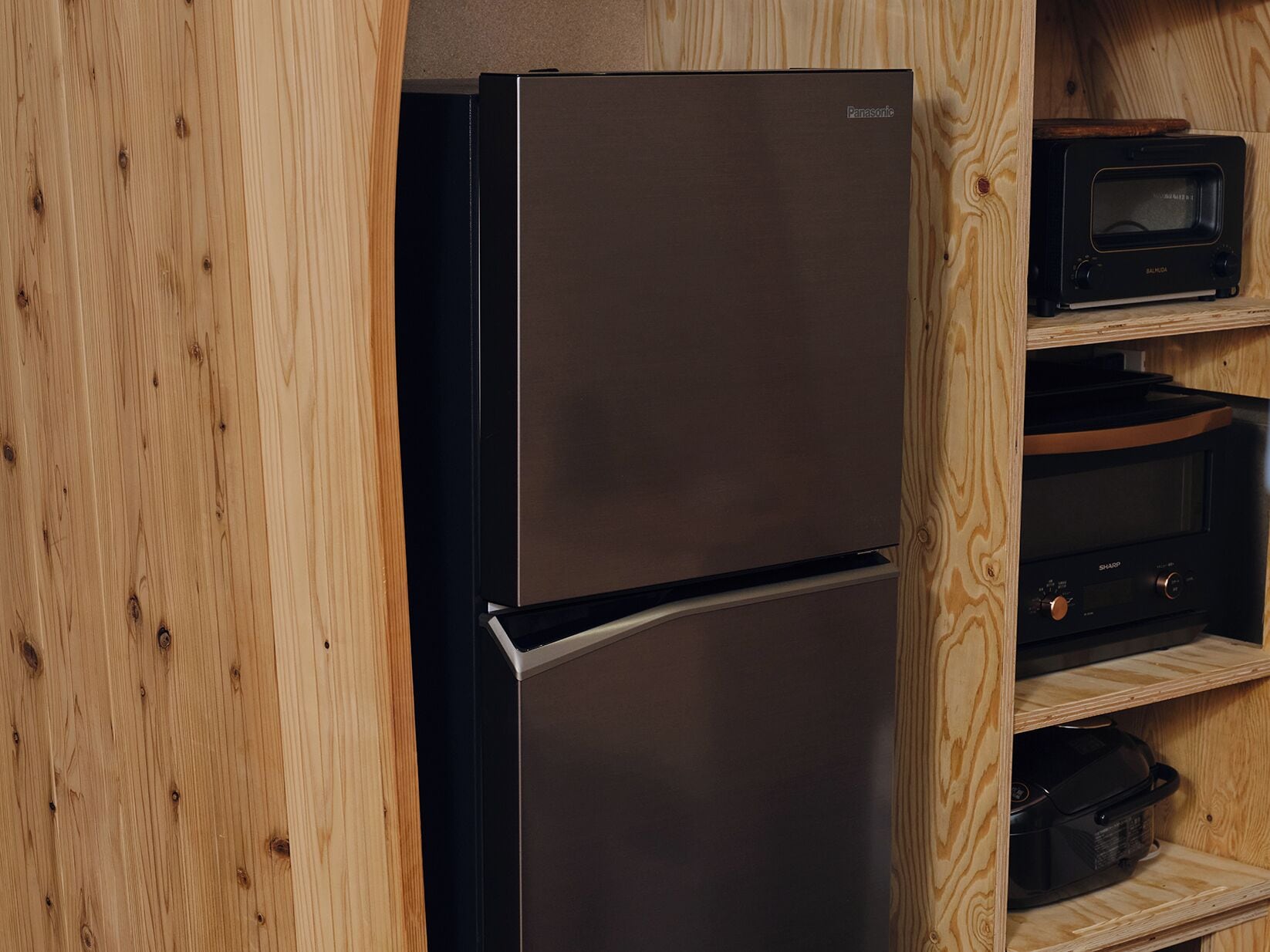 A modern kitchen with a stainless steel refrigerator, a microwave, and a built-in oven.