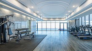 A modern gym with various exercise equipment, large windows, and a city view. - Dancenter Jeddah Near King Fahd's Fountain (Jeddah)