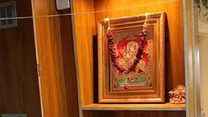 A reception desk labeled "RECEPTION" with a framed religious picture above it. - Shera Inn (Ahmedabad)