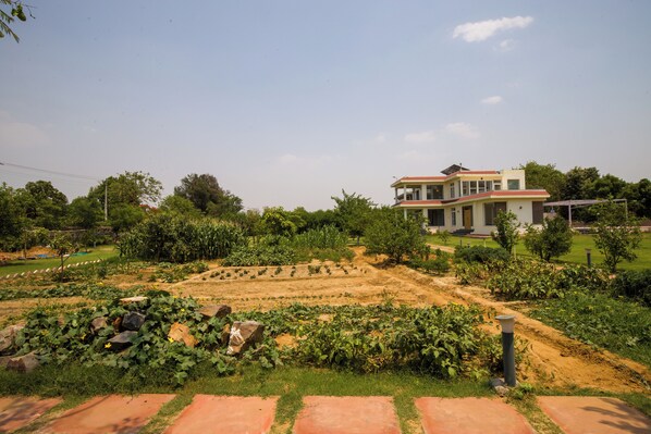 A modern house with a garden in front. - Alaya Stays Raga 2BHK Farmstay (Sohna)