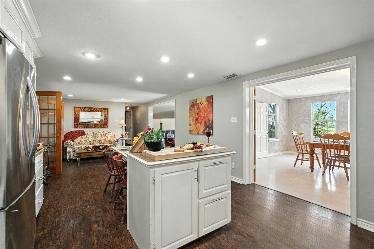 Una cocina amplia con comedor, suelo de madera y vista al salón comedor.