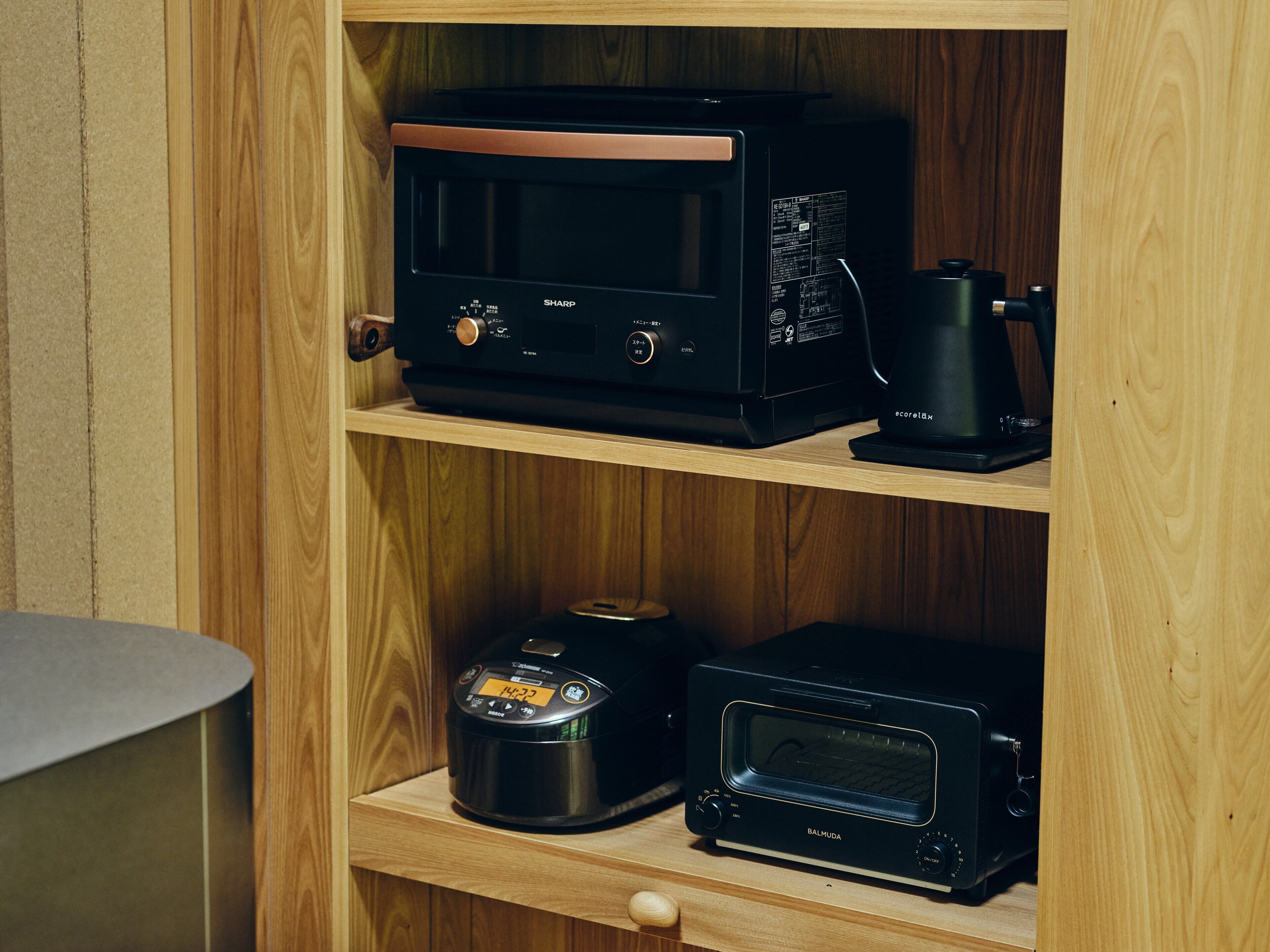 A kitchen with a microwave, toaster, and coffee maker on wooden shelves.