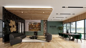 A modern living room with a sofa, coffee table, and a dining area with a table and chairs. There is a bookshelf and a wall with the word "REGARD" on it. - Regards At Med Center 130 I Spacious 1 Bed 1 Bath (Houston)