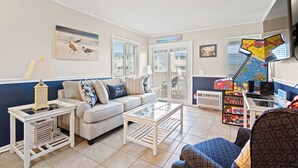 A living room with a sofa, coffee table, and a TV stand. - Cozy Condo close to the Beach and Pool in Shore Drive (Myrtle Beach)