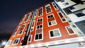 Ein mehrgeschossiges Gebäude mit roter Backsteinfassade und weißen Fensterrahmen.