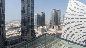 Um edifício alto com fachada de vidro moderna, rodeado por outros arranha-céus.