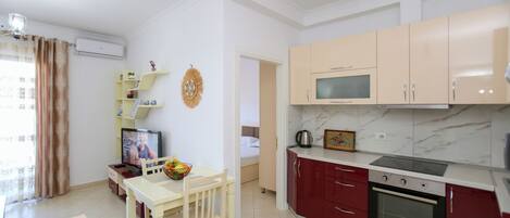 A compact kitchen with a dining area, a TV, and a microwave.