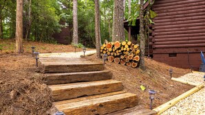 A wooden staircase leading to a cabin surrounded by trees. - Timber & Tranquility Cabin (Pine Mountain)
