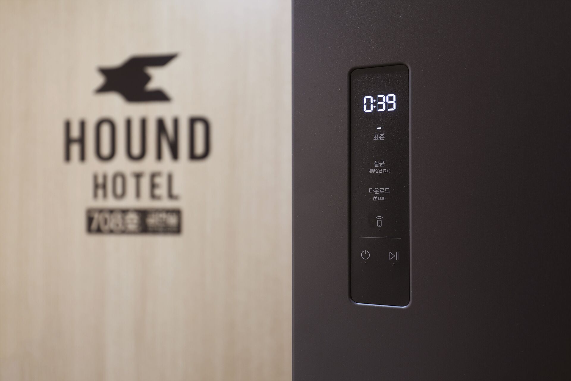 A digital display with the time '0:39' and a logo for 'HOUND HOTEL' with a stylized animal head.