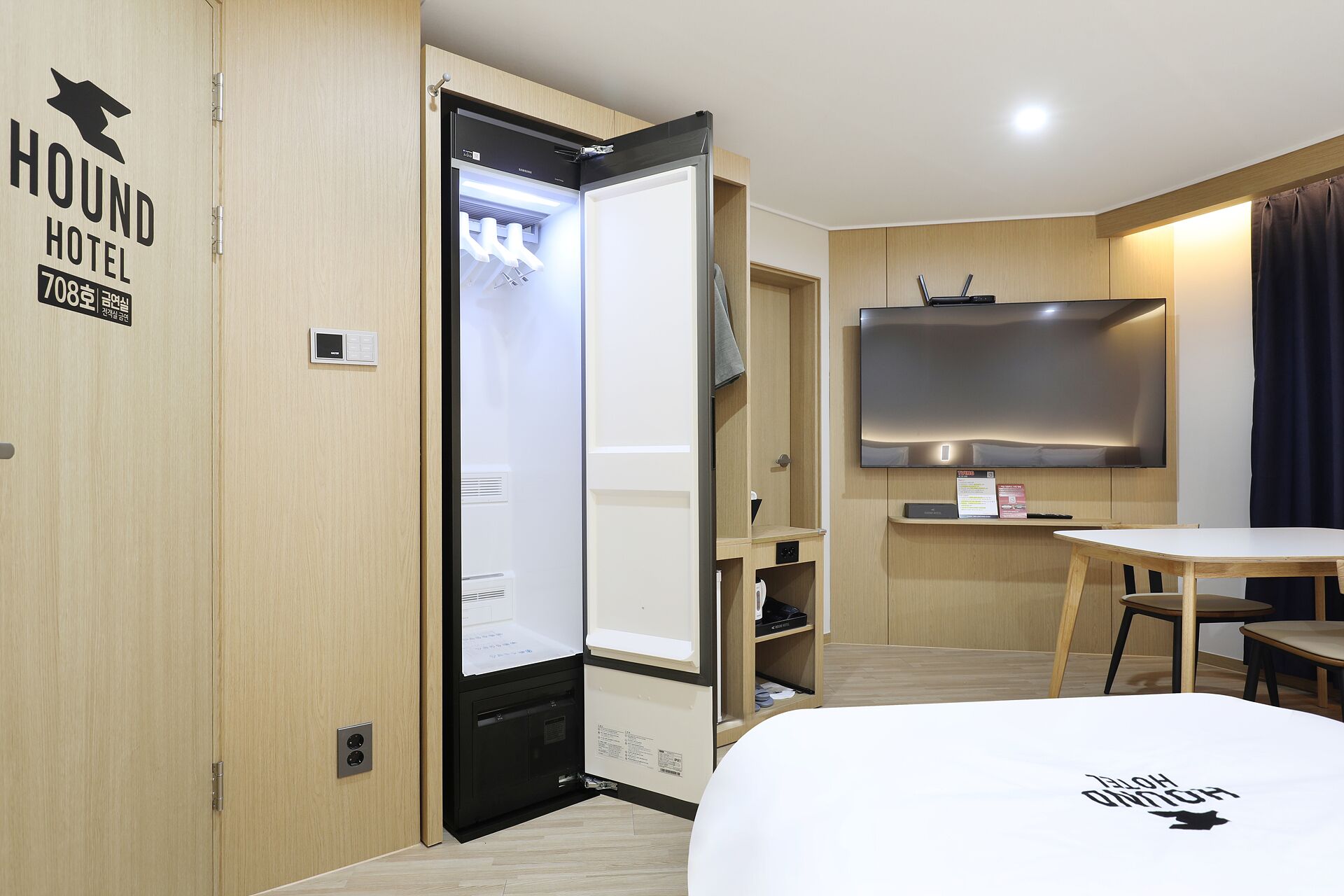 A hotel room with a bed, a desk, a television, and a wardrobe.