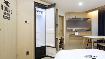 A hotel room with a bed, a desk, a television, and a wardrobe.