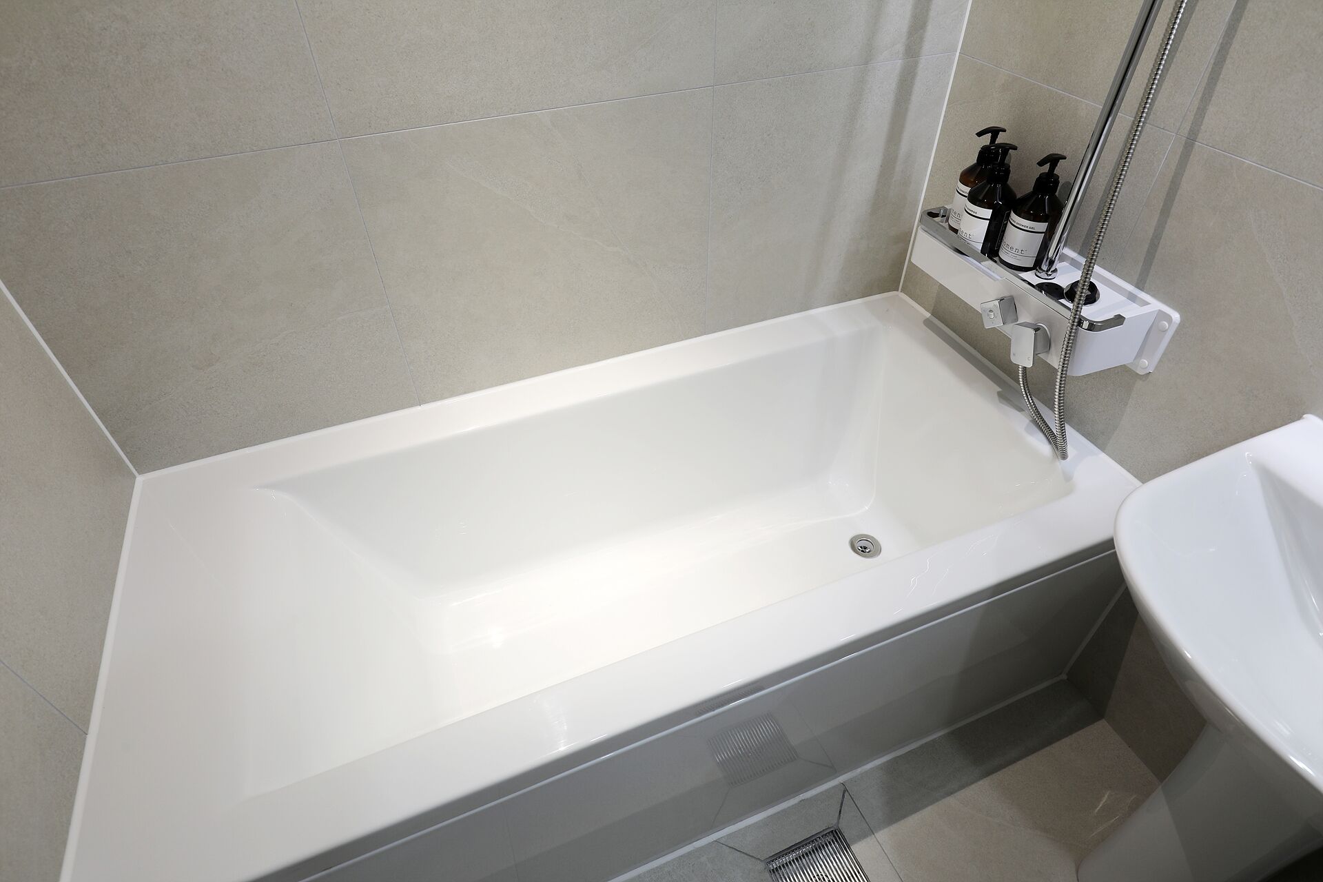 Un baño moderno con una bañera blanca, ducha e lavamanos.