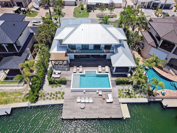 A large house with a swimming pool, a dock, and a patio area.