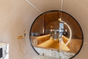 A circular room with a wooden floor, a glass wall, and a shower area. - Private Airplane Lodge - Sauna & outdoor jacuzzi (Uurainen)