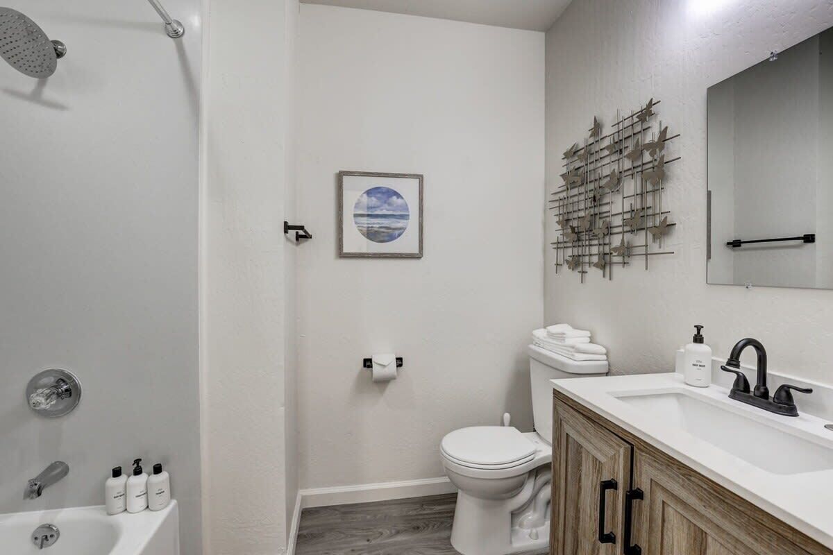 Et moderne badeværelse med brusebad, toilet og håndvask.