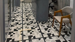 Un moderno vestíbulo de hotel con mostrador de recepción, zona de estar y baldosas de suelo estampadas.