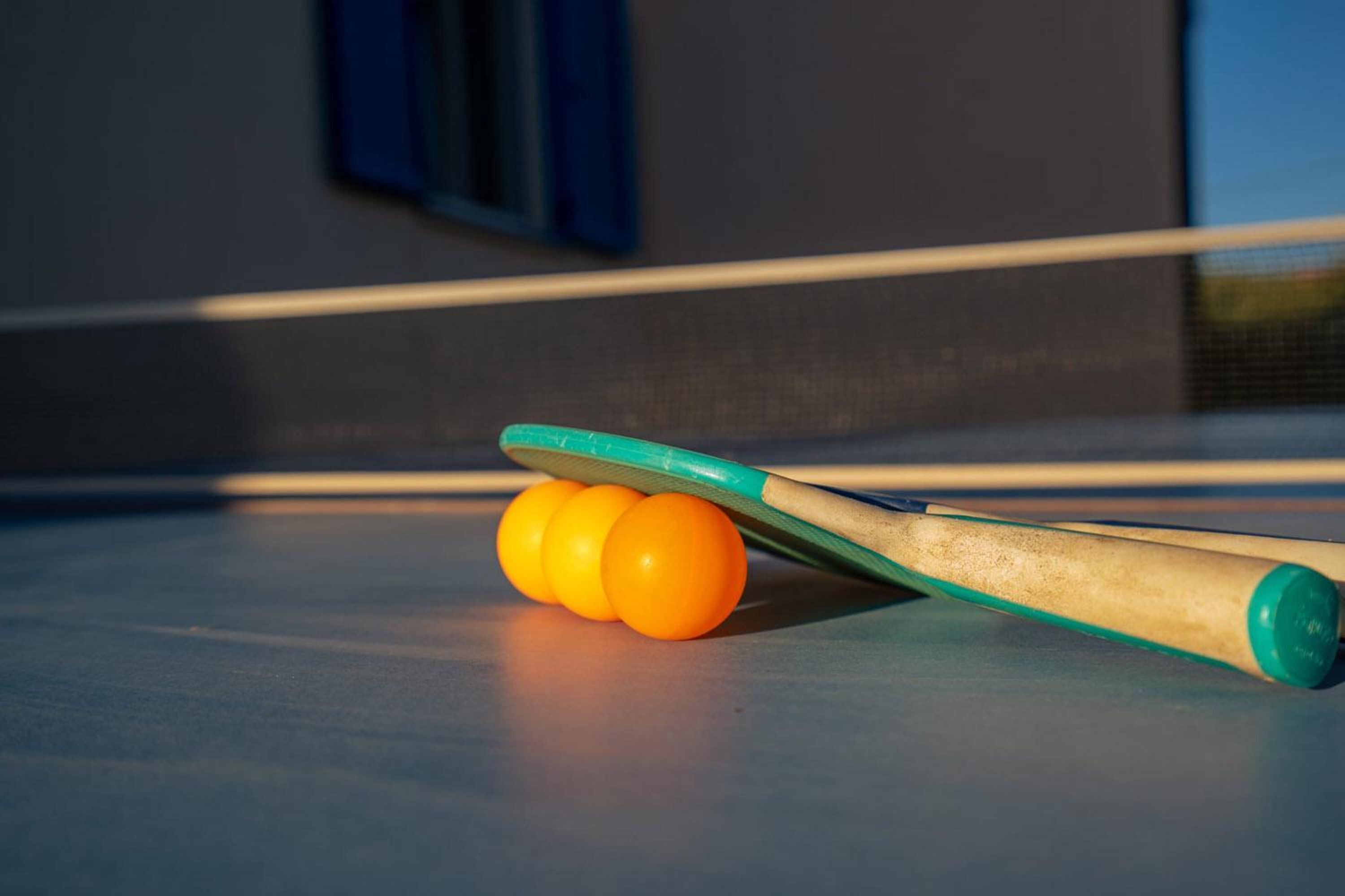 A pool table with a cue stick and three orange billiard balls.