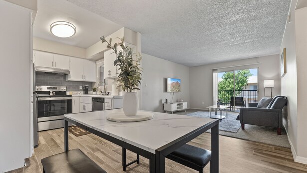 A modern kitchen with white cabinets, a central island, and a dining table with benches. - Pool -Gym- Great for Mid/Long Stays (Mesa)