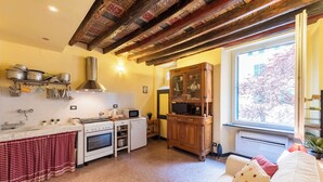 Een keuken met een fornuis, oven, magnetron en houten kastjes.