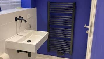 A small bathroom with a white sink, a toilet, and a towel.