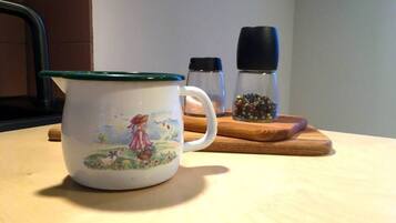 Una taza de cerámica con tapa verde sobre una mesa de madera.