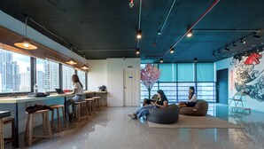 Een moderne werkruimte met een bar, zitplaatsen en grote ramen met uitzicht op de stad.
