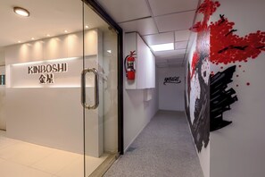 A hallway with a glass door labeled 'KINBOSHI' and a fire extinguisher mounted on the wall.